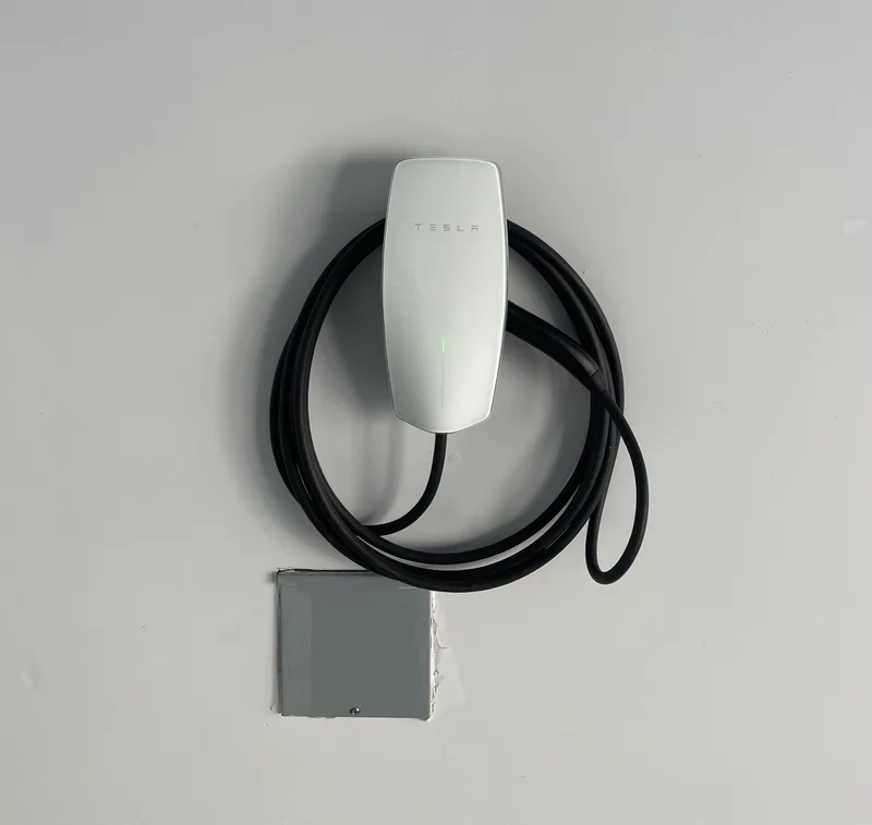 Tesla Wall Connector installed on garage wall with clean conduit run in Placerville home